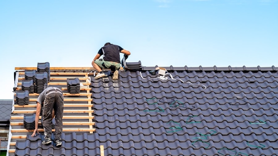 craftsman builds a new roof from ceramic tiles.