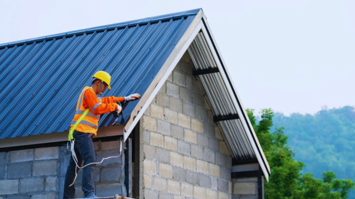 A man wearing an orange vest is repairing a roof, showcasing professional roof repair services in Ridgeland, SC.