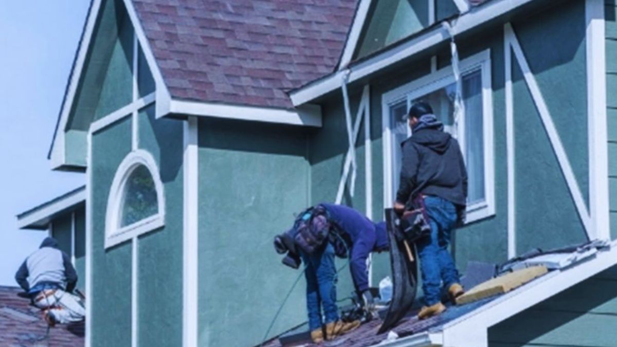 Three individuals working together on a roof in Ridgeland, engaged in residential roofing maintenance and installation.