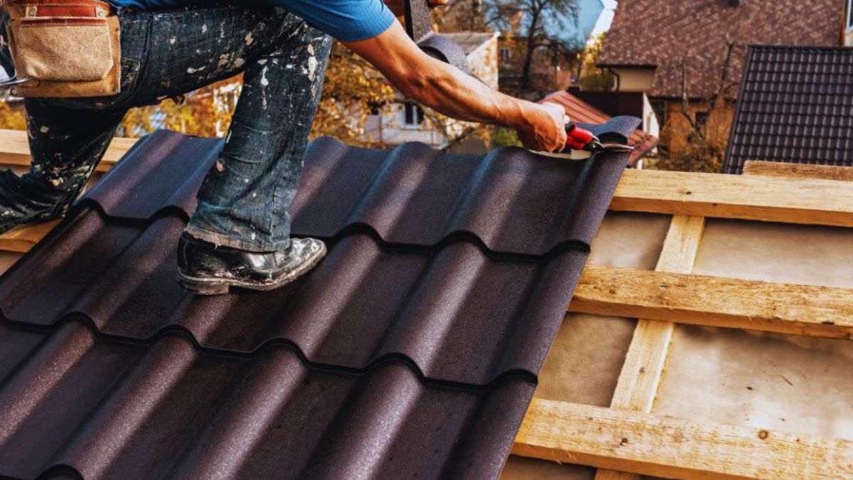 Roof installation in Ridgeland showing a contractor securing metal roofing panels on a residential home using professional tools and safety gear.