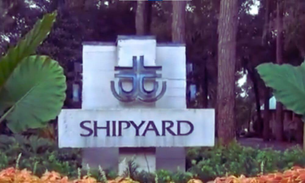 Entrance sign for Shipyard Plantation on Hilton Head Island, surrounded by lush greenery and tall trees.