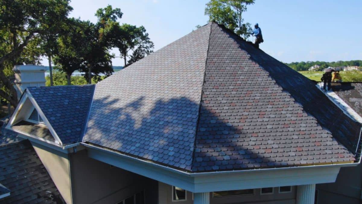 Roof repair crew working on a large shingle roof of a coastal home in Hilton Head Island, SC.