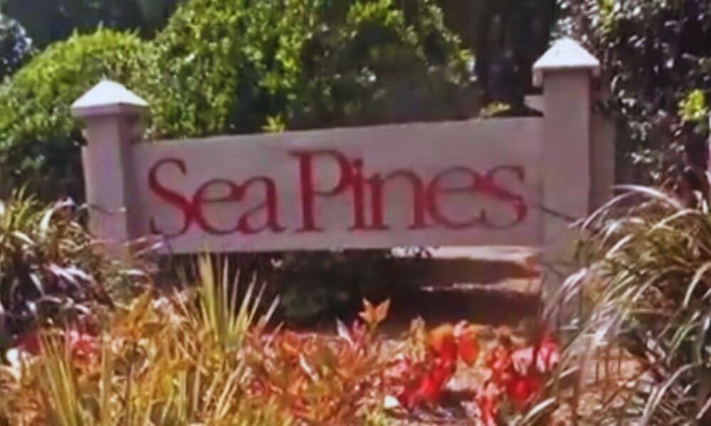 Sea Pines Plantation entrance sign surrounded by lush landscaping and palm plants on Hilton Head Island.
