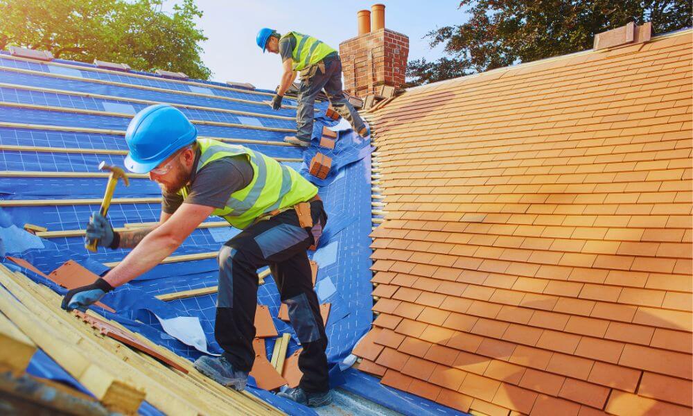 Roofing contractors installing shingles on a residential roof in Sea Pines Plantation, using safety gear and tools during a roofing service project.