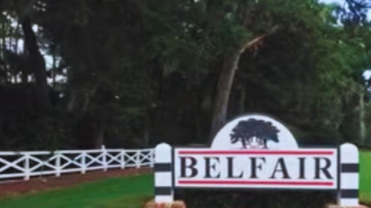 Belfair Plantation entrance monument sign with white fencing and landscaped green lawn at the community entrance in Bluffton, South Carolina.