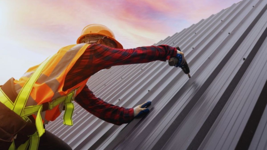 Contractor installing a standing seam metal roof on a residential building, showcasing professional metal roofing services by a metal roofing company in Hilton Head, SC.