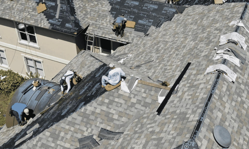 Roof inspectors examining ridge shingles and flashing